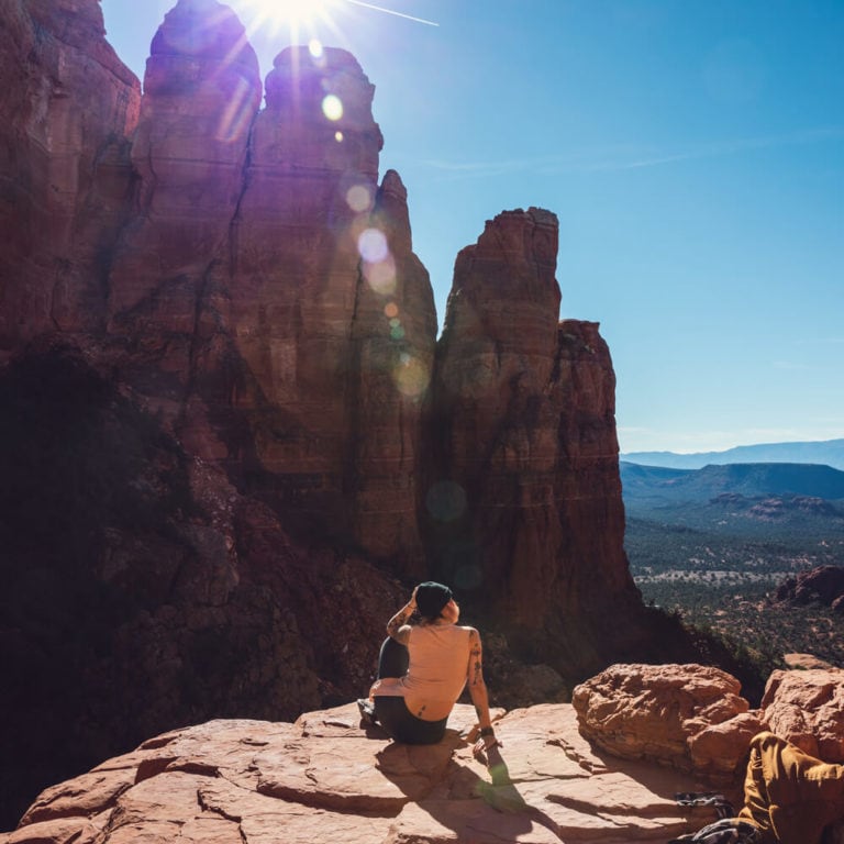 Person sitting on top of the red rocks of Sedona