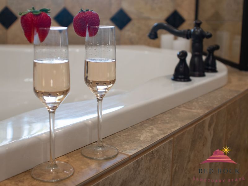 Stemmed glasses next to a romantic luxury bathtub